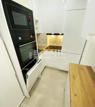 Modern white kitchen with built-in appliances and wooden elements. - image 3