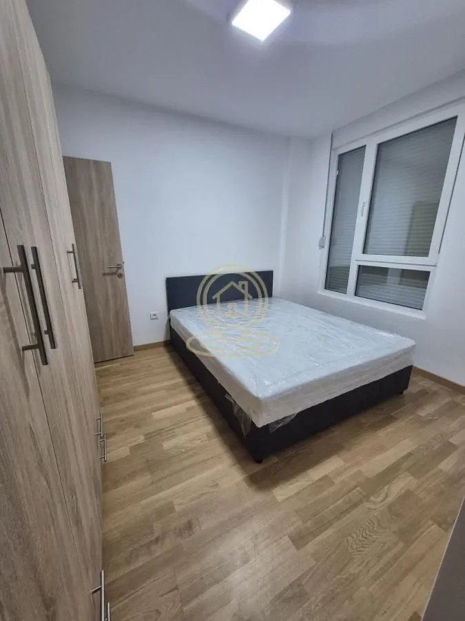 Nameštena spavaća soba sa bračnim krevetom i ormarom.
