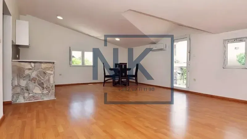 Spacious living room with wooden flooring, a dining table and a small bar counter.