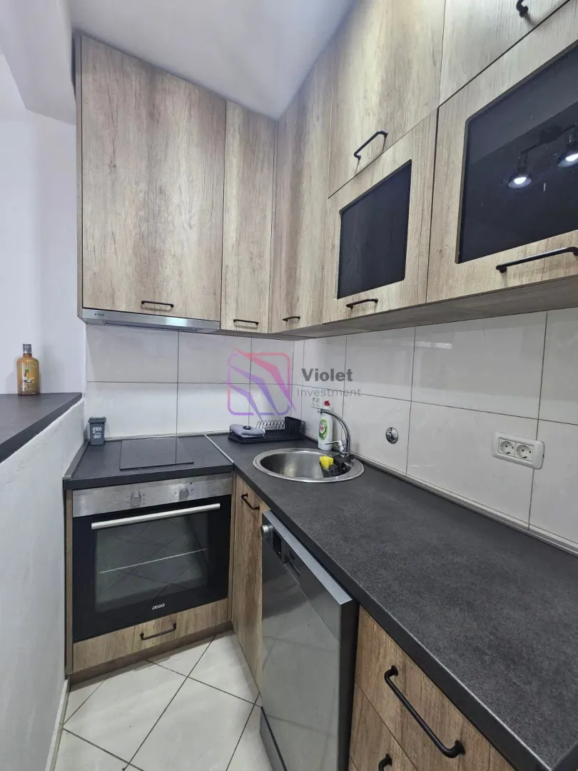 Small equipped kitchen with wooden elements and built-in appliances.