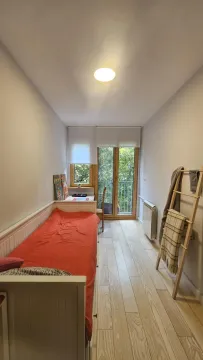 Long bedroom with a bed, desk, and access to the terrace. - image 12