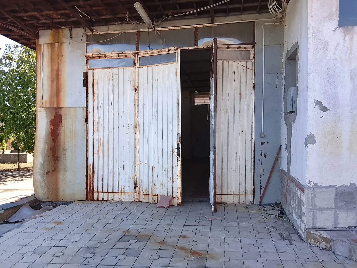 View of the entrance to a commercial space or warehouse with large white doors.