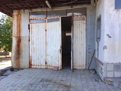 View of the entrance to a commercial space or warehouse with large white doors. - image 12