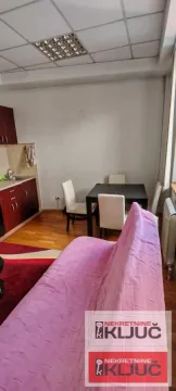 Dnevna soba sa garniturom, trpezarijskim stolom i manjom kuhinjom u uglu. - image 4