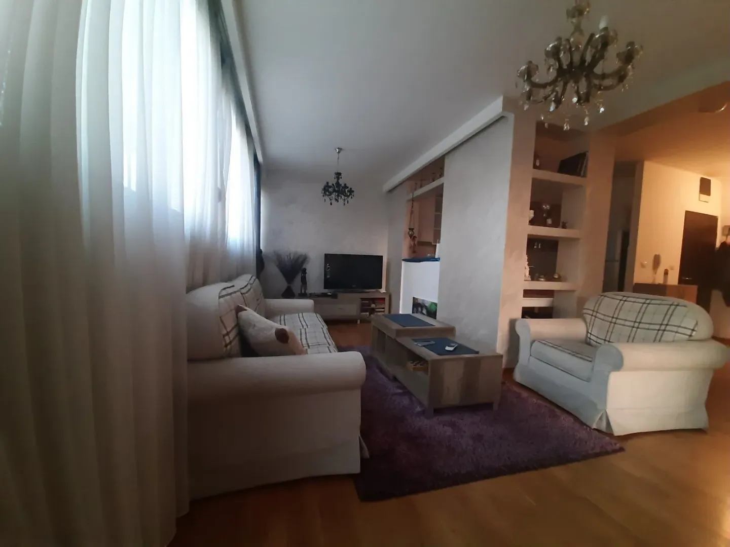 Bright living room with comfortable furniture and a television.