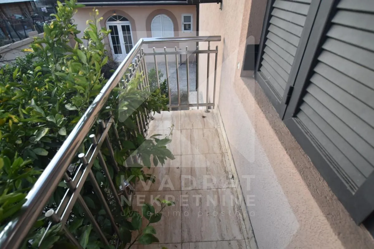 Balcony with metal railing and yard view.