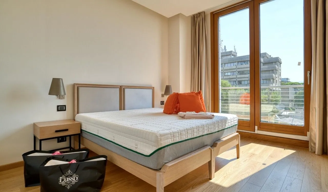Bedroom with a double bed and large balcony doors.