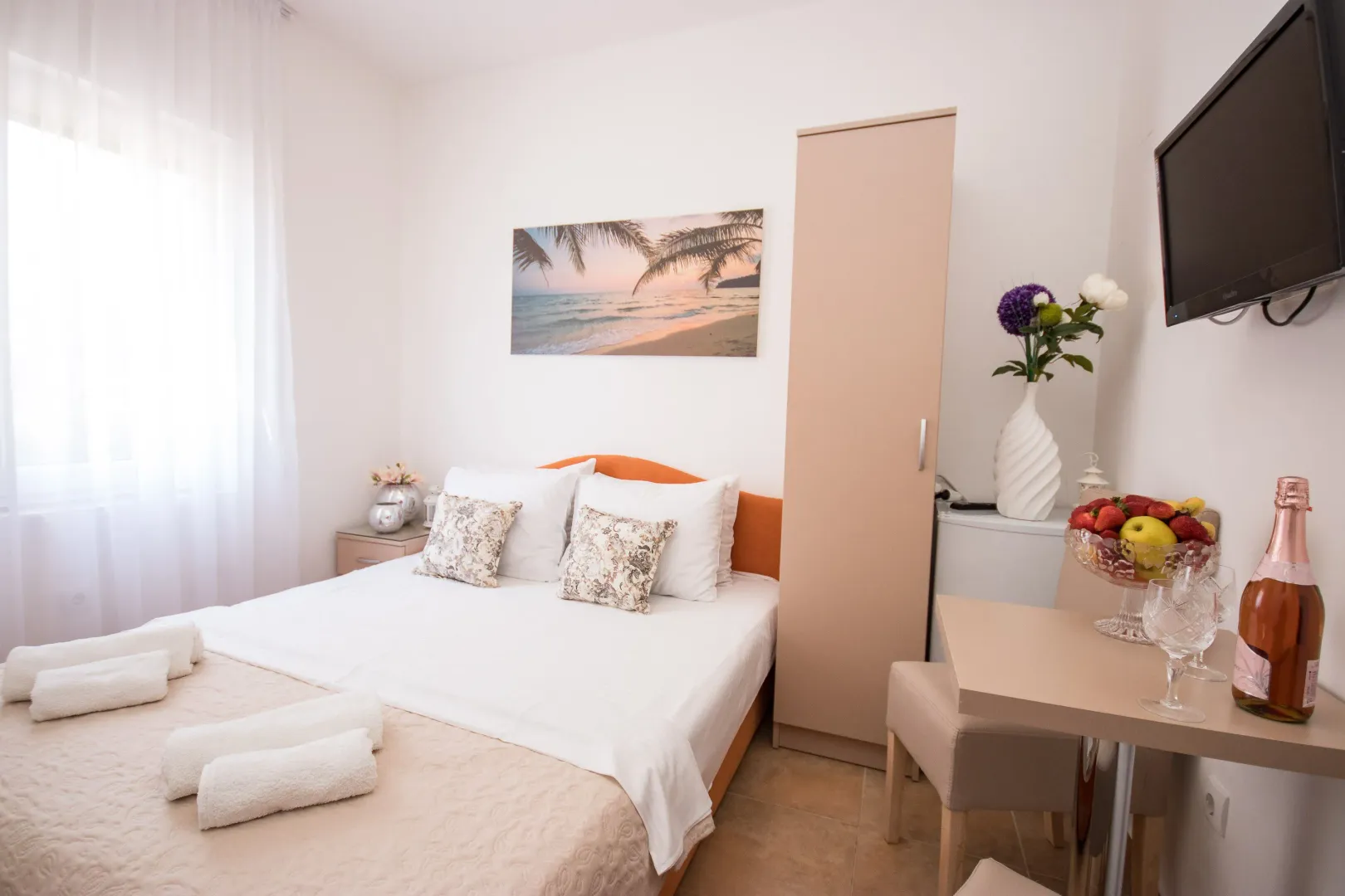 Furnished bedroom with a double bed, wardrobe, and TV.
