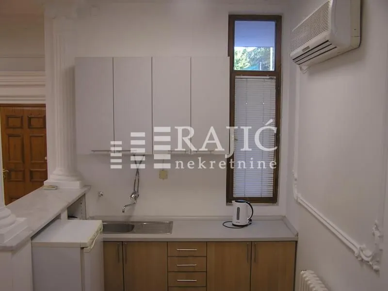 Small kitchen with wooden lower cabinets and white upper cabinets.