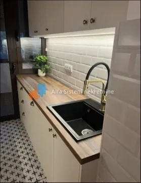 Small kitchen with white cabinets, wooden countertop and black sink. - image 4