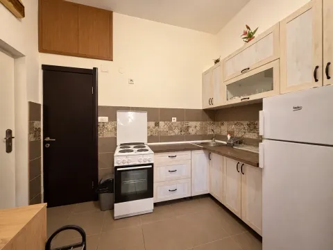 Smaller kitchen with white cabinetry, stove, and refrigerator. - image 5