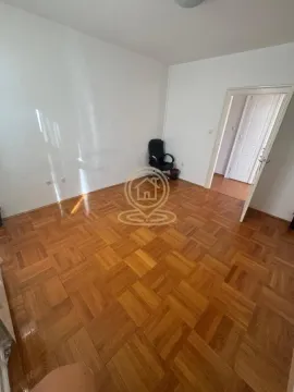 Empty room with parquet flooring and an office chair in the corner. - image 4