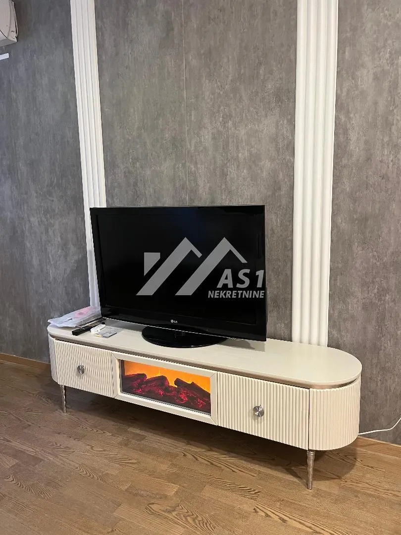 TV komoda sa ugrađenim kaminom i televizorom u dnevnoj sobi.