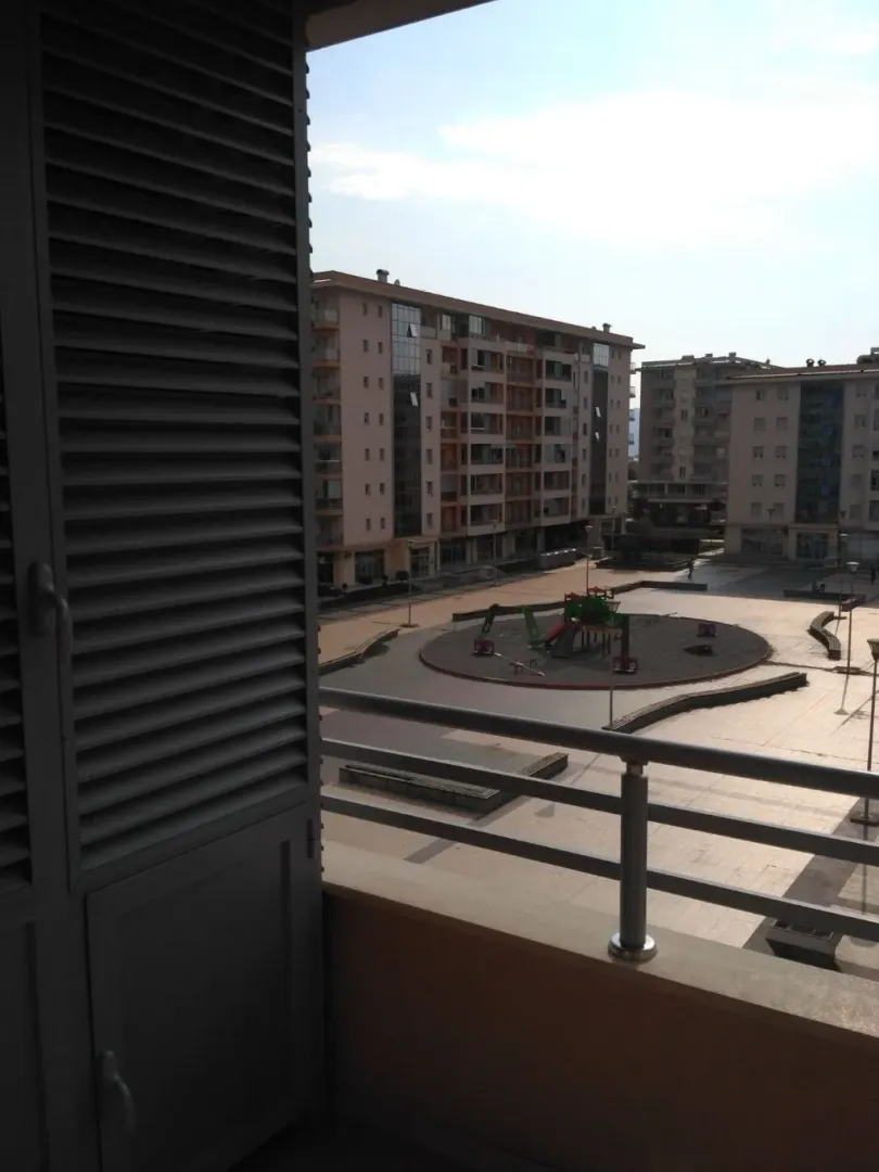 View from the balcony overlooking surrounding residential buildings and a playground.