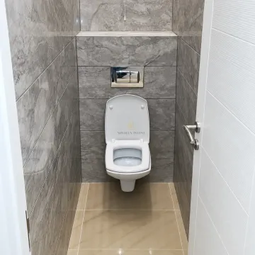 Small bathroom lined with grey tiles and a wall-hung toilet. - image 4