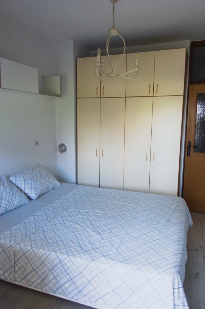 Furnished bedroom with a double bed and a large wardrobe.
