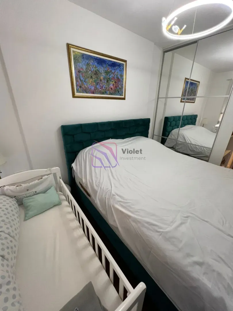 Bedroom with a double bed and a baby crib.