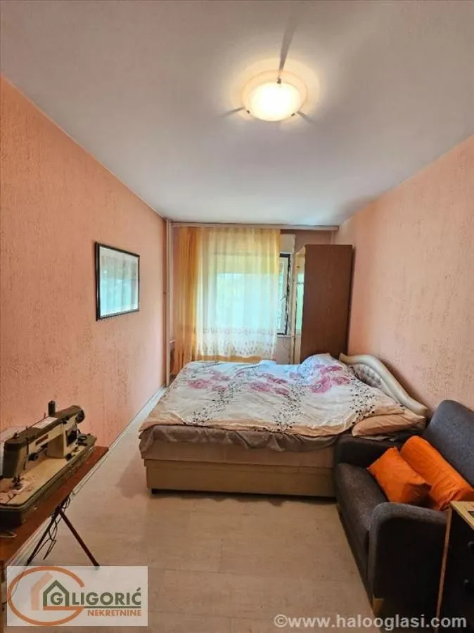 Furnished bedroom with a double bed, sofa, and desk.