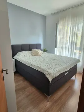 Furnished bedroom with a double bed and curtained window. - image 5