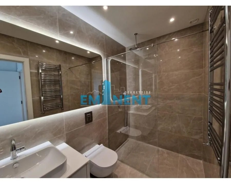 Modern bathroom equipped with a walk-in shower, washbasin, and built-in sanitary ware.