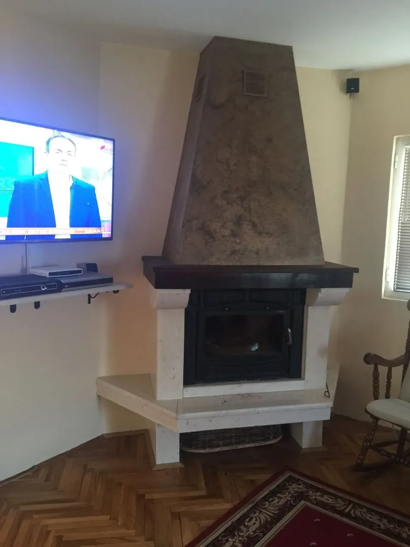 Part of a living room featuring a fireplace and a wall-mounted TV.