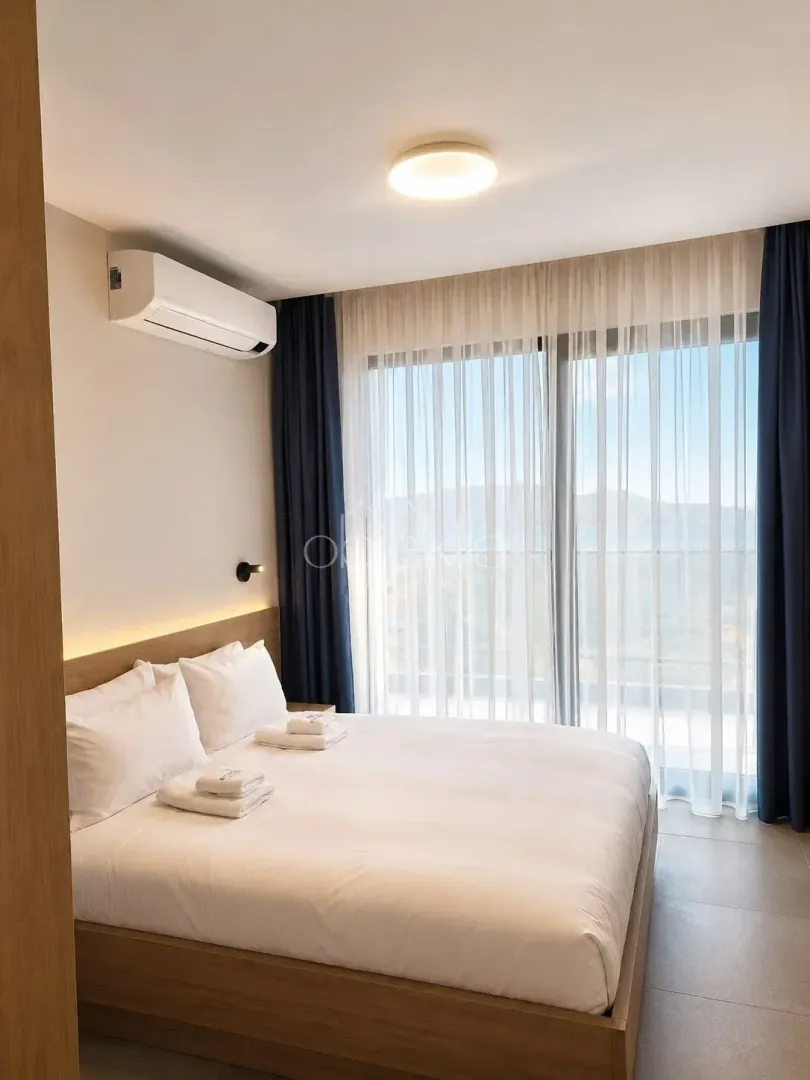 Modern bedroom with a double bed, air conditioning, and a large window.