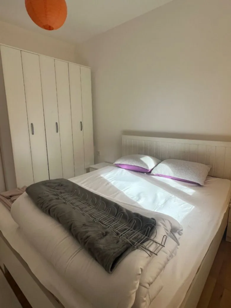 Spavaća soba sa bračnim krevetom i bijelim garderoberom.
