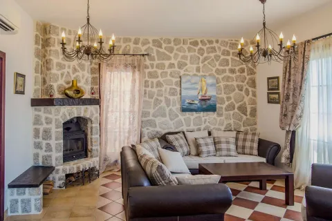 Dnevna soba sa kaminom obloženim kamenom i garniturom za sjedenje. - image 10