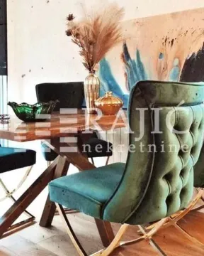 Dining area with a wooden table and green upholstered chairs. - image 4