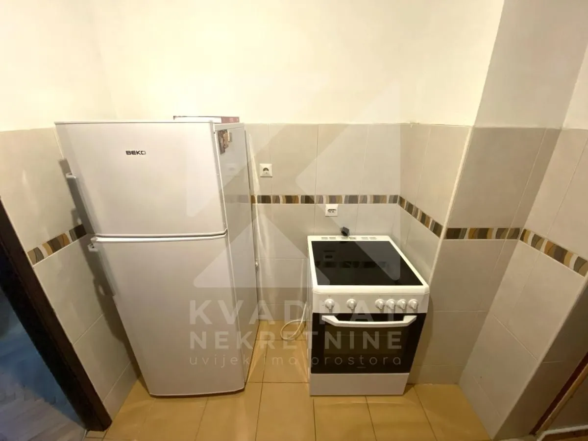 Small kitchen with a refrigerator and a stove.
