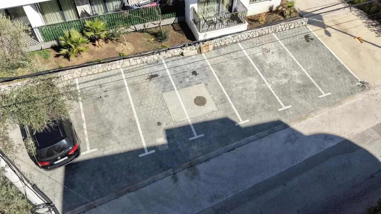 High-angle view of a paved parking area with marked parking spaces.