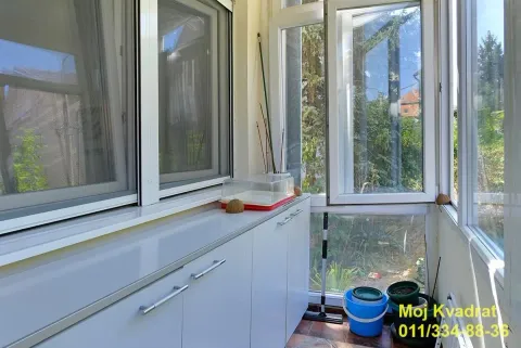 Zastakljena terasa sa ugradnim ormarićima i pogledom na zelenilo. - image 16