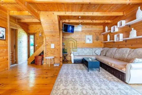 Wood-paneled living room with a sofa and stairs. - image 2