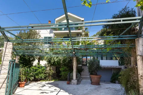 Pogled na dvorište i fasadu kuće sa pergolom prekrivenom lozom. - image 30