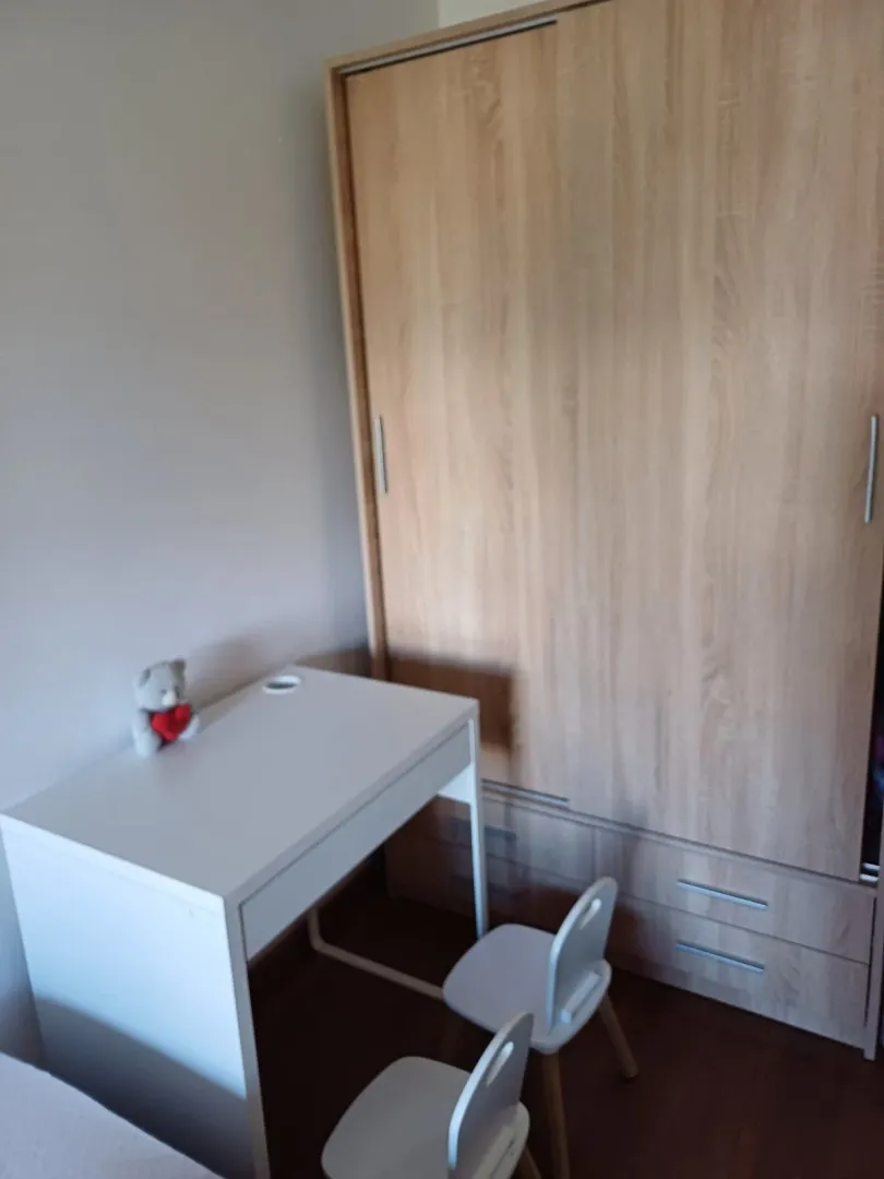 Radni sto sa dječijim stolicama i veliki drveni ormar.