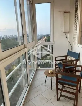 Enclosed balcony with seating furniture and a city view. - image 5
