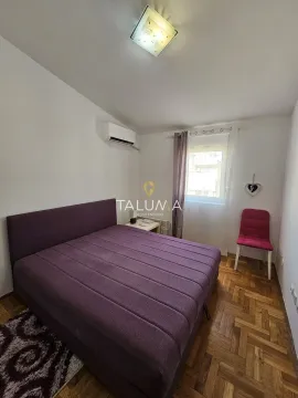 Furnished bedroom with a double bed, air conditioning, and a window. - image 7