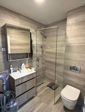 Moderno opremljeno kupatilo sa tuš kabinom i drvenim zidnim oblogama. - image 6