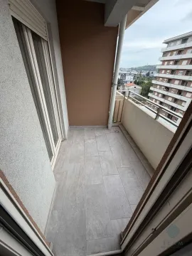 Nakatkrivena terasa sa keramičkim pločicama i pogledom na grad. - image 8