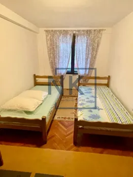 Bedroom with two wooden beds and a window with curtains. - image 3