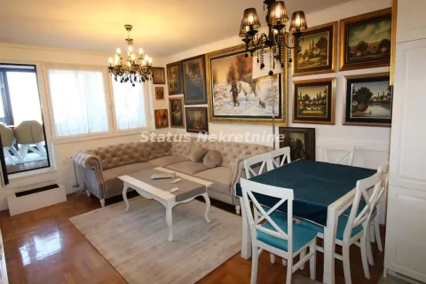 Living room with a sofa set, dining table, and a wall filled with paintings. - image 2