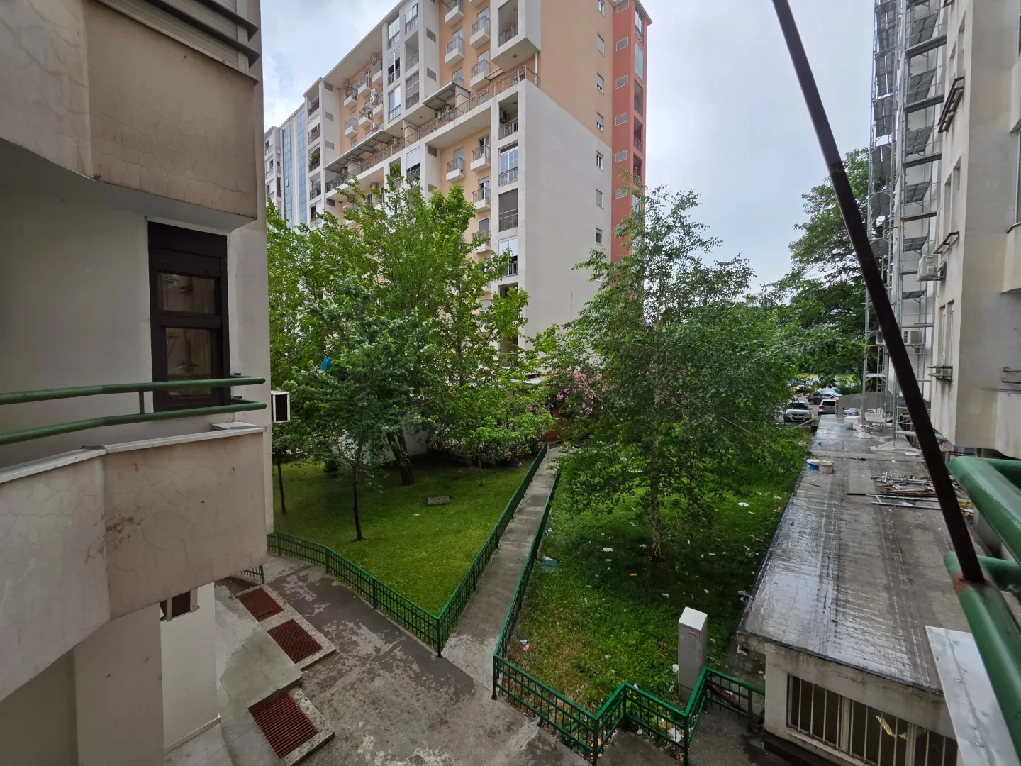 View from the building onto a courtyard with greenery and surrounding residential buildings.
