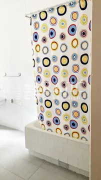Bathroom with a bathtub and a colorful shower curtain. - image 9
