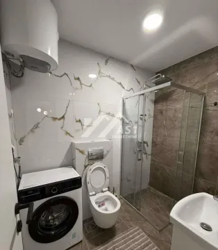 Savremeno opremljeno kupatilo sa tuš kabinom, WC šoljom i veš mašinom. - image 6