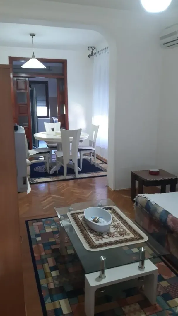 Dnevna soba sa trpezarijom i parketom na podu.