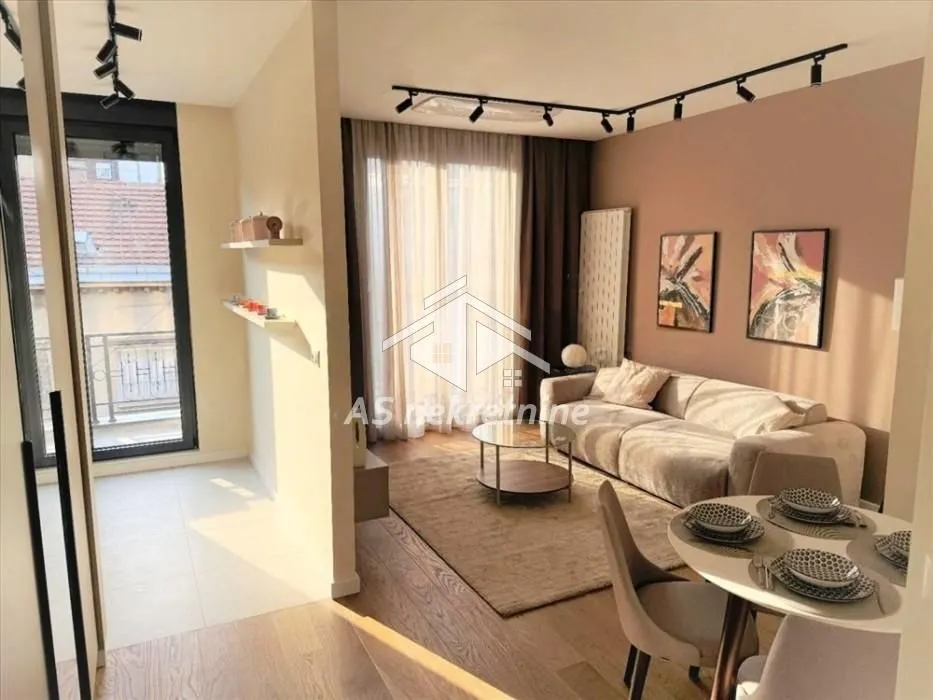 Living room with a sofa, dining table, and access to the terrace.
