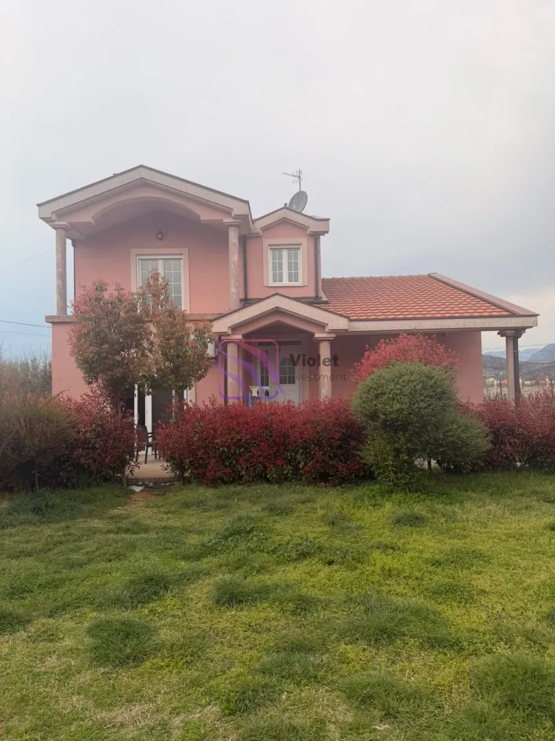Exterior of a two-story house with a landscaped yard and lawn.