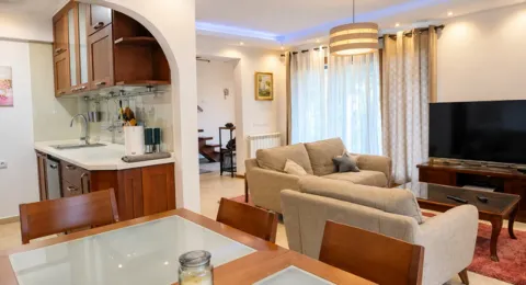 Living room with a dining area and an open kitchen. - image 3