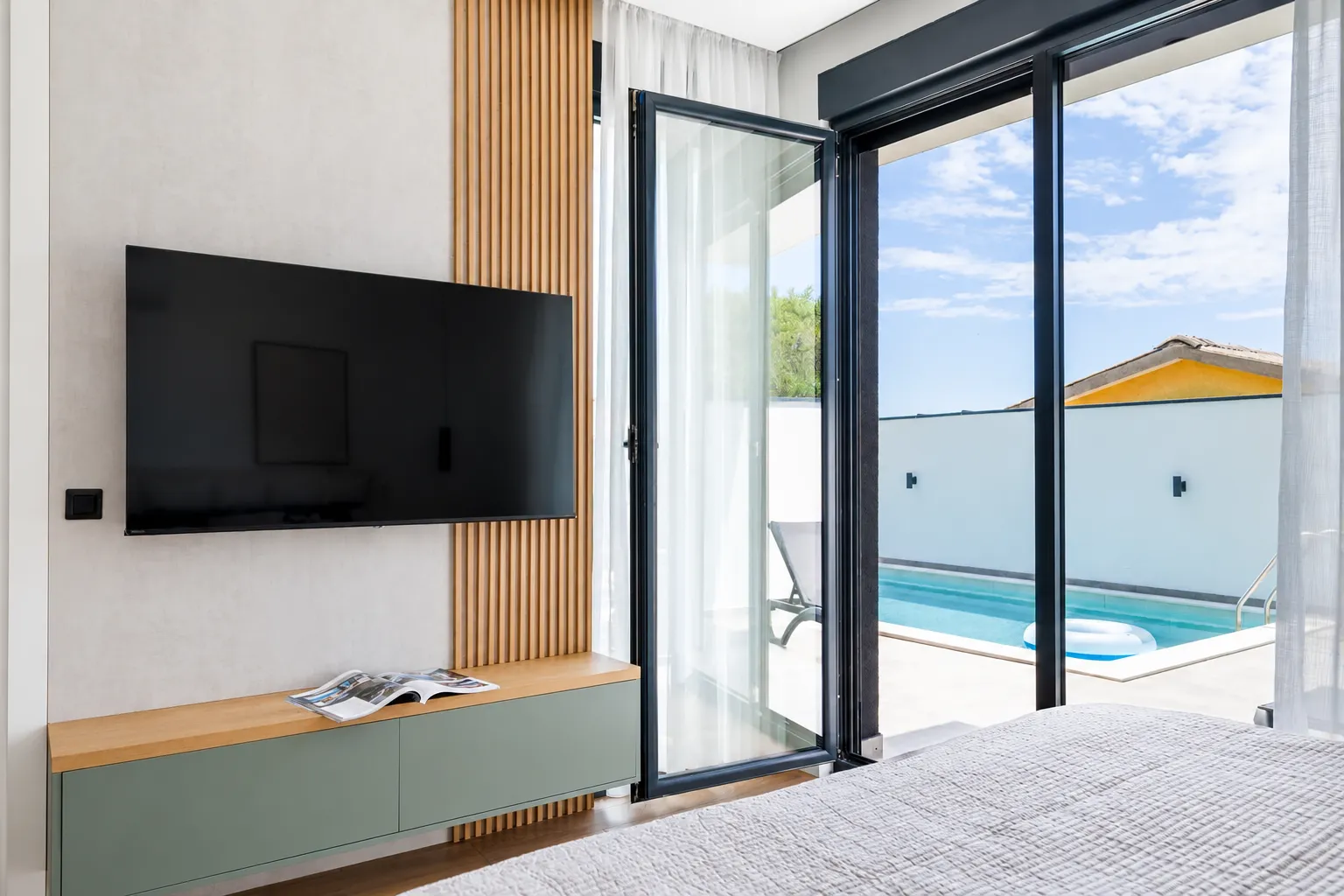 Bedroom with a large double bed and direct access to the terrace with a swimming pool.