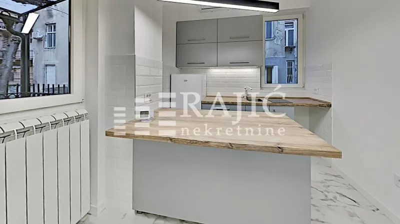 Modern kitchen with a breakfast bar and white cabinetry.